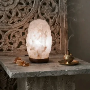 Lámpara de mesa encendida de cristal de roca en tono blanco natural de 3 a 5Kg de peso, sobre pedestal de madera