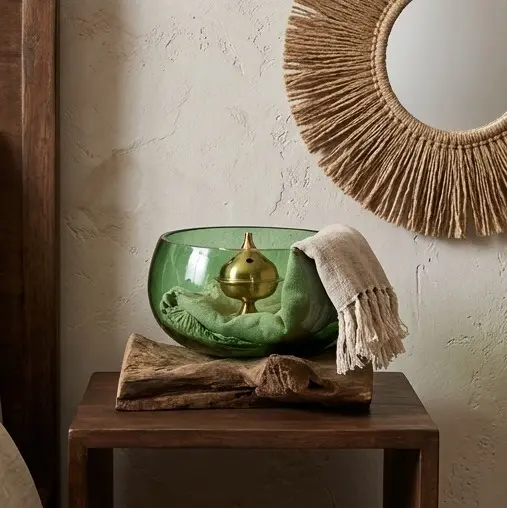Cuenco de vidrio reciclado color verde fundido sobre base de madera natural